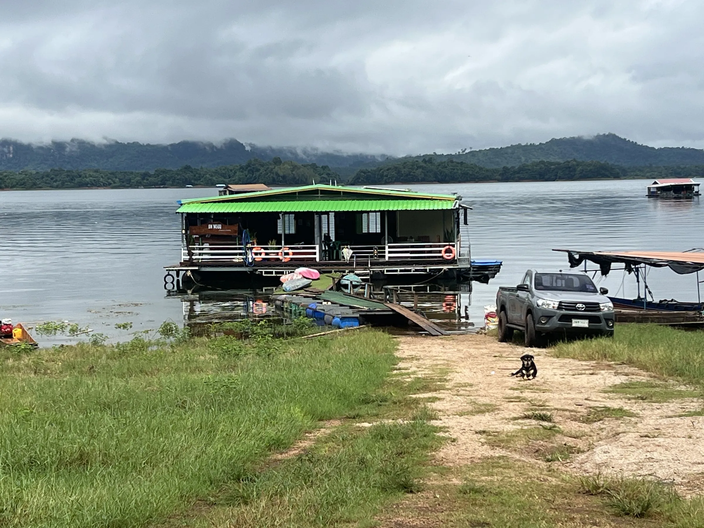 The raft house tied up at the grassy shore with a minivan parked alongside.