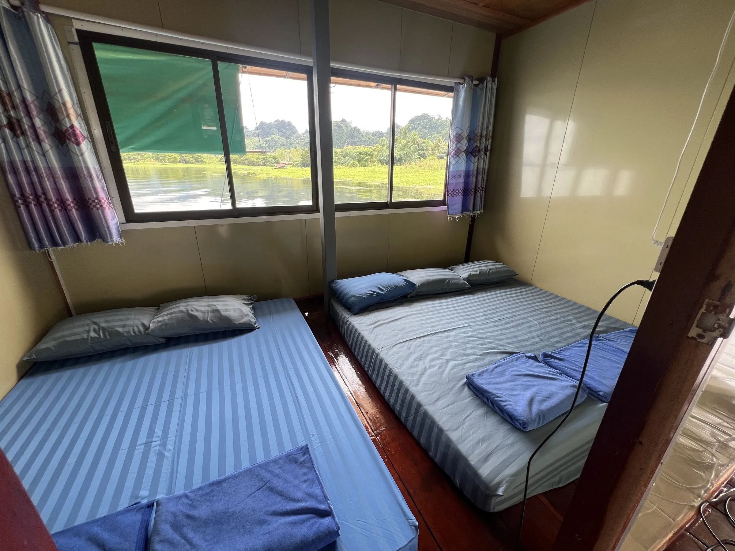 A private room on the raft with mattresses on a low platform and a window onto the lake.