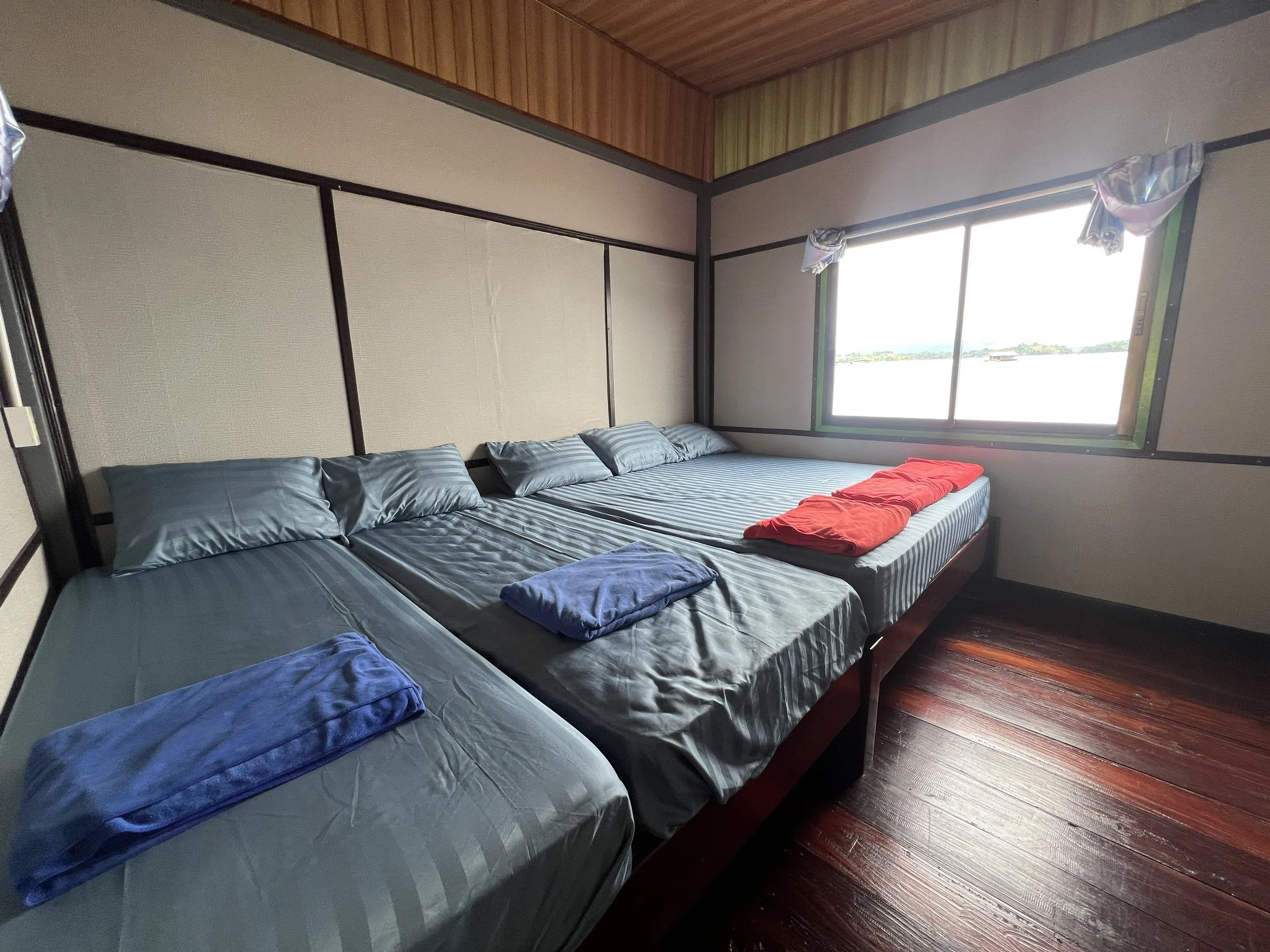 A private room with three mattresses on low platforms and folded towels.